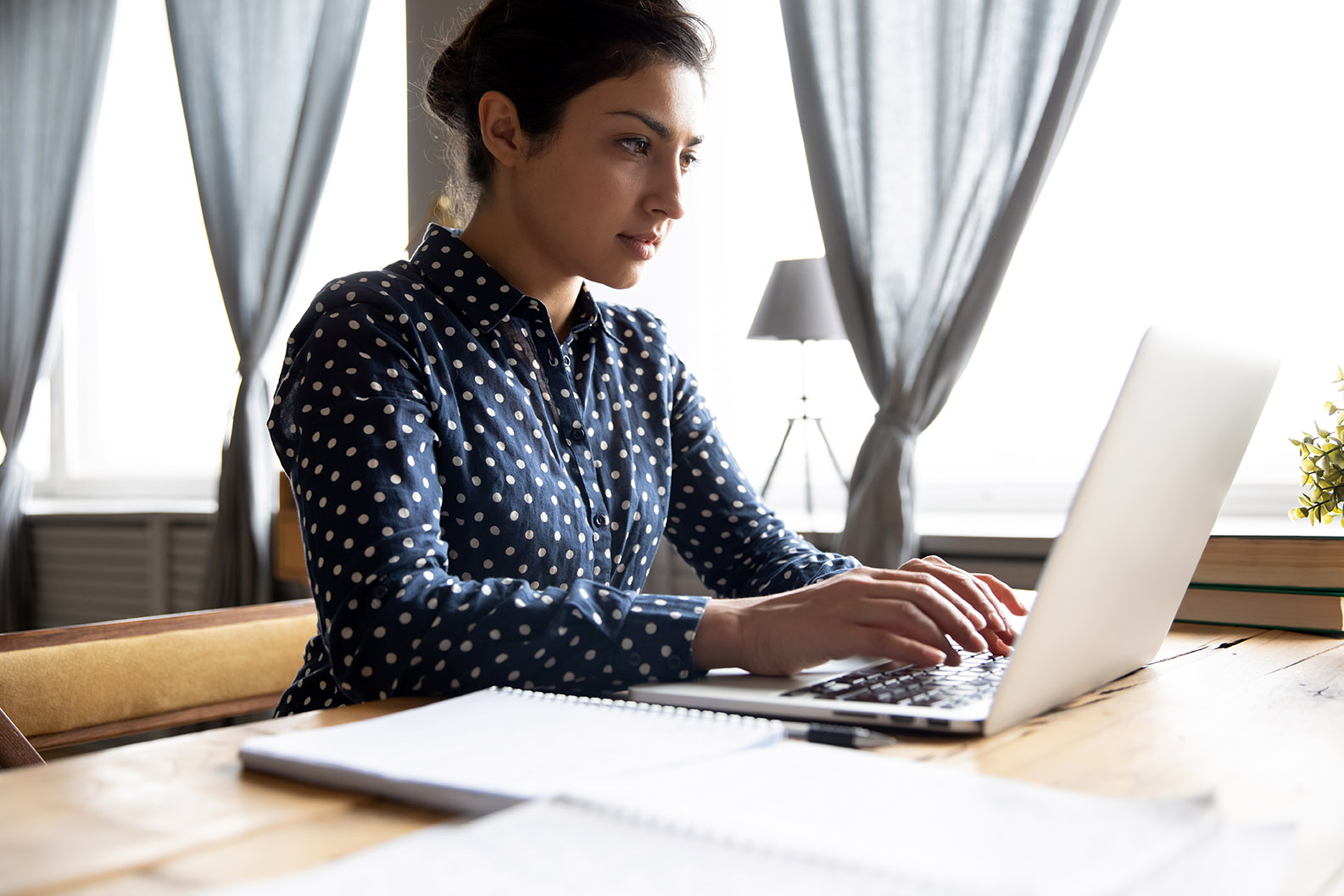 woman typing transcription on laptop