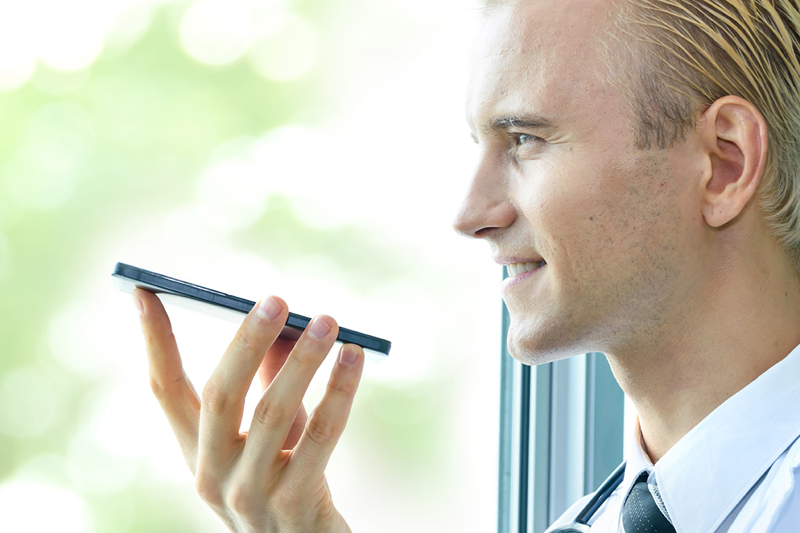 doctor speaking into a digital recorder