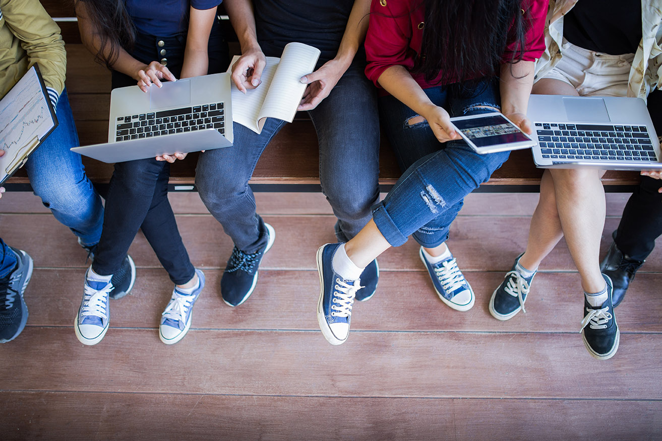 students working on computers and tablets