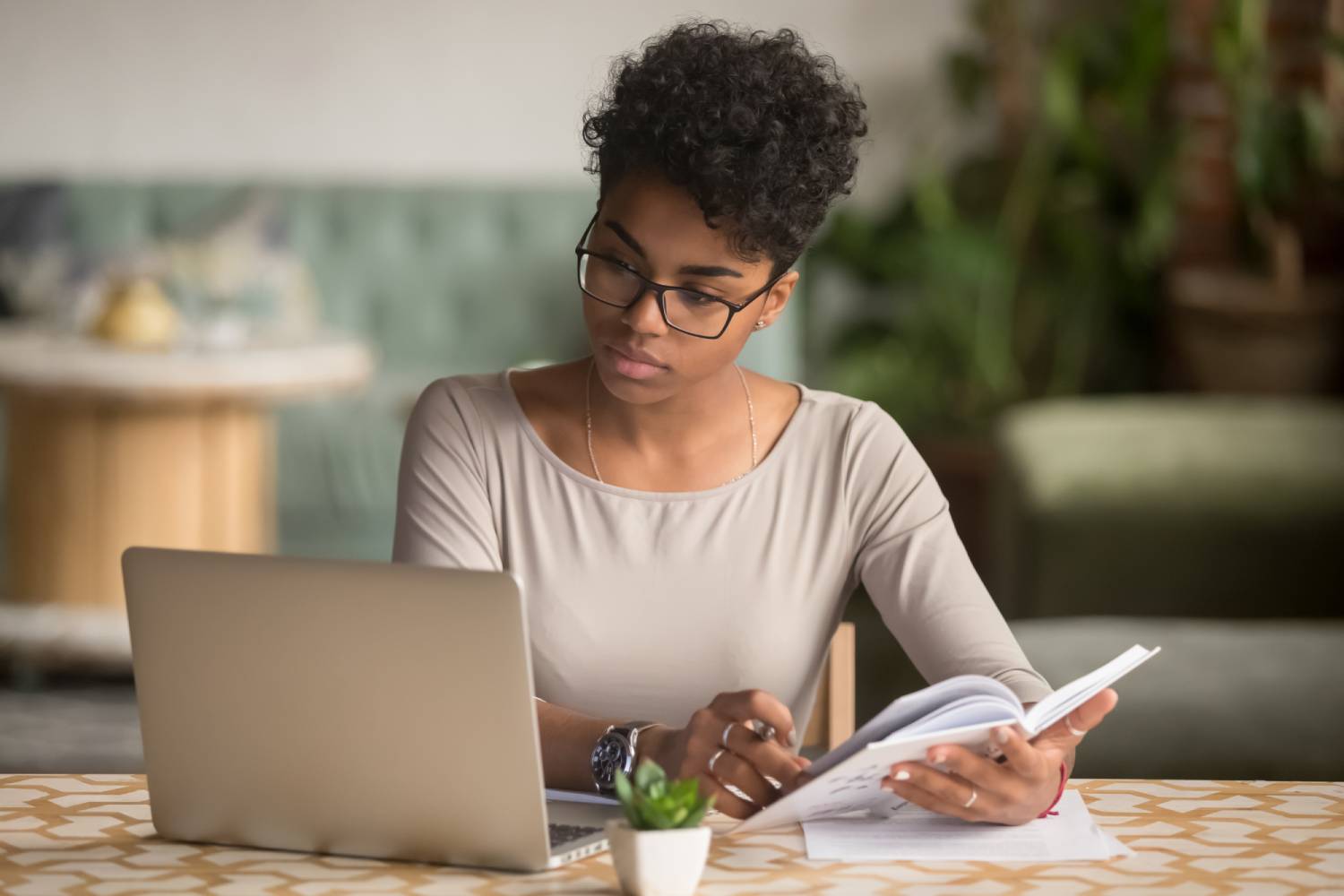 Woman looking at laptop with notepad - transcription researchers